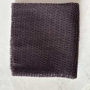 Black African net sponge laid flat on a pale floor